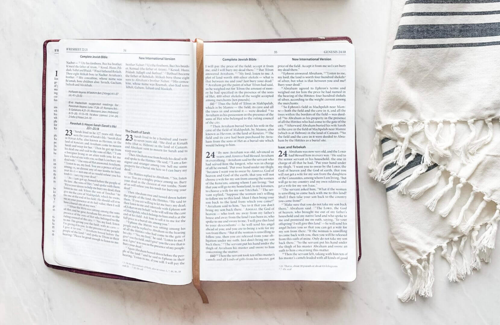 Open book with highlighted text and a pen on a white surface.