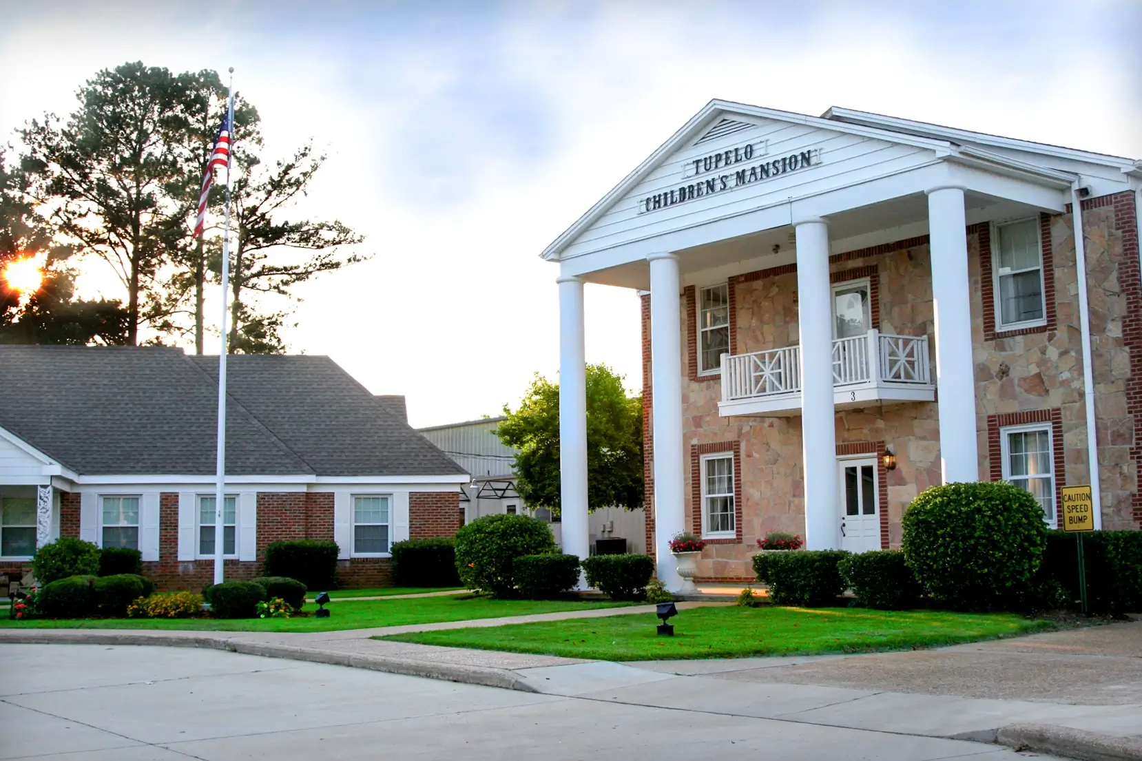 A library building with white columns and brick walls on a sunny day.